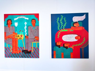 Two paintings hang on a wall. At left a woman and man sit on yellow chairs facing each other. At right, a swaddled baby lies on a red table; a woman above is sleeping, while below two women look a the baby.