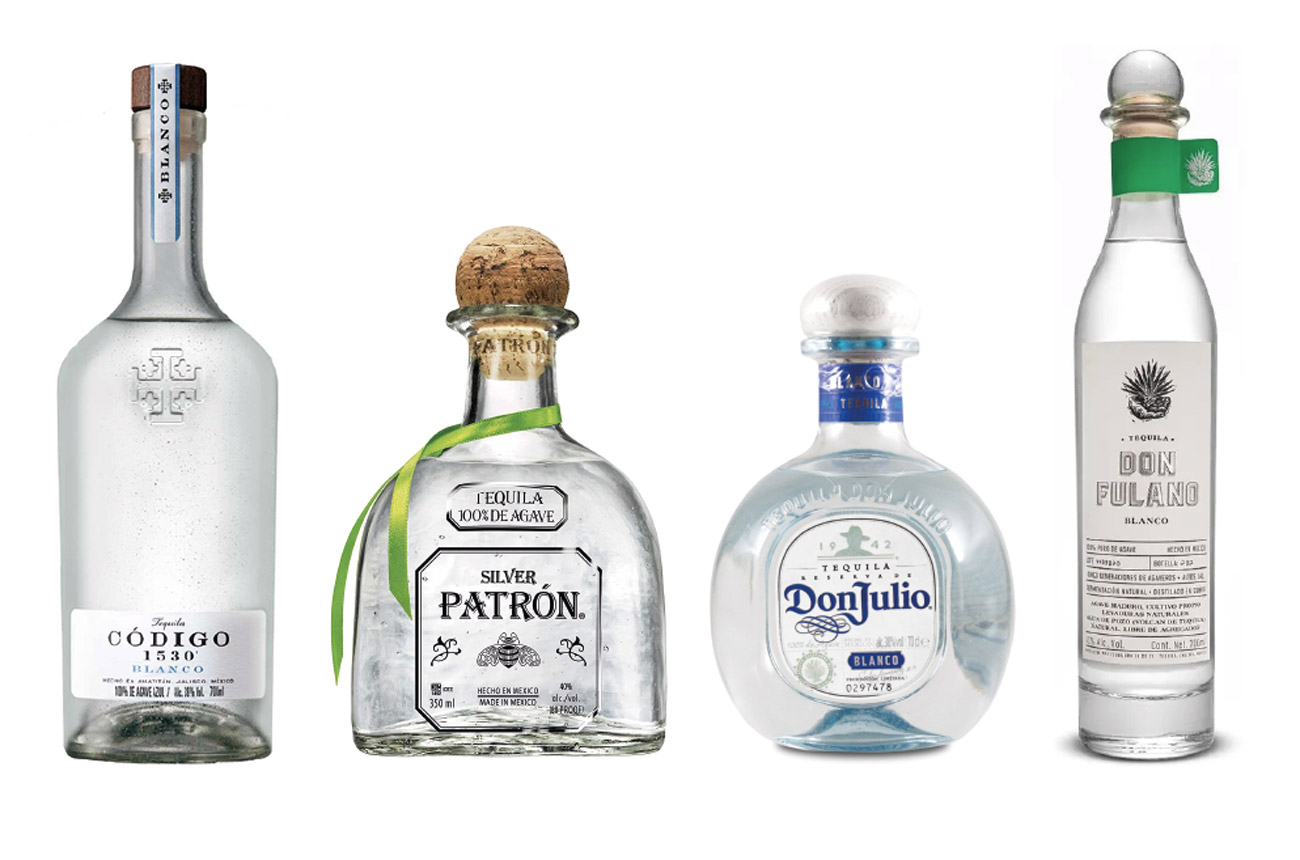 Four bottles of clear tequila against a white background