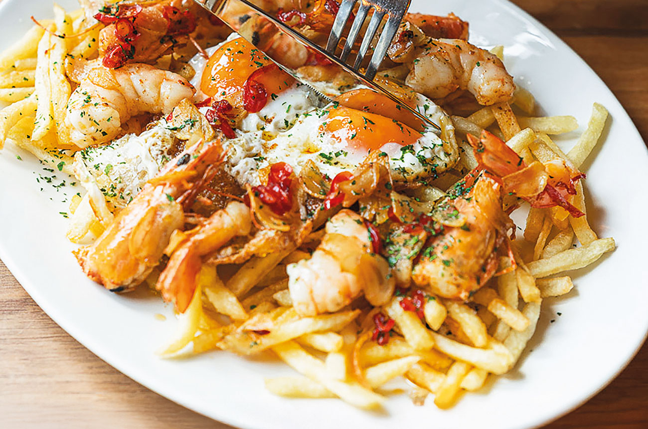 Gamba blanca al ajillo con huevos rotos