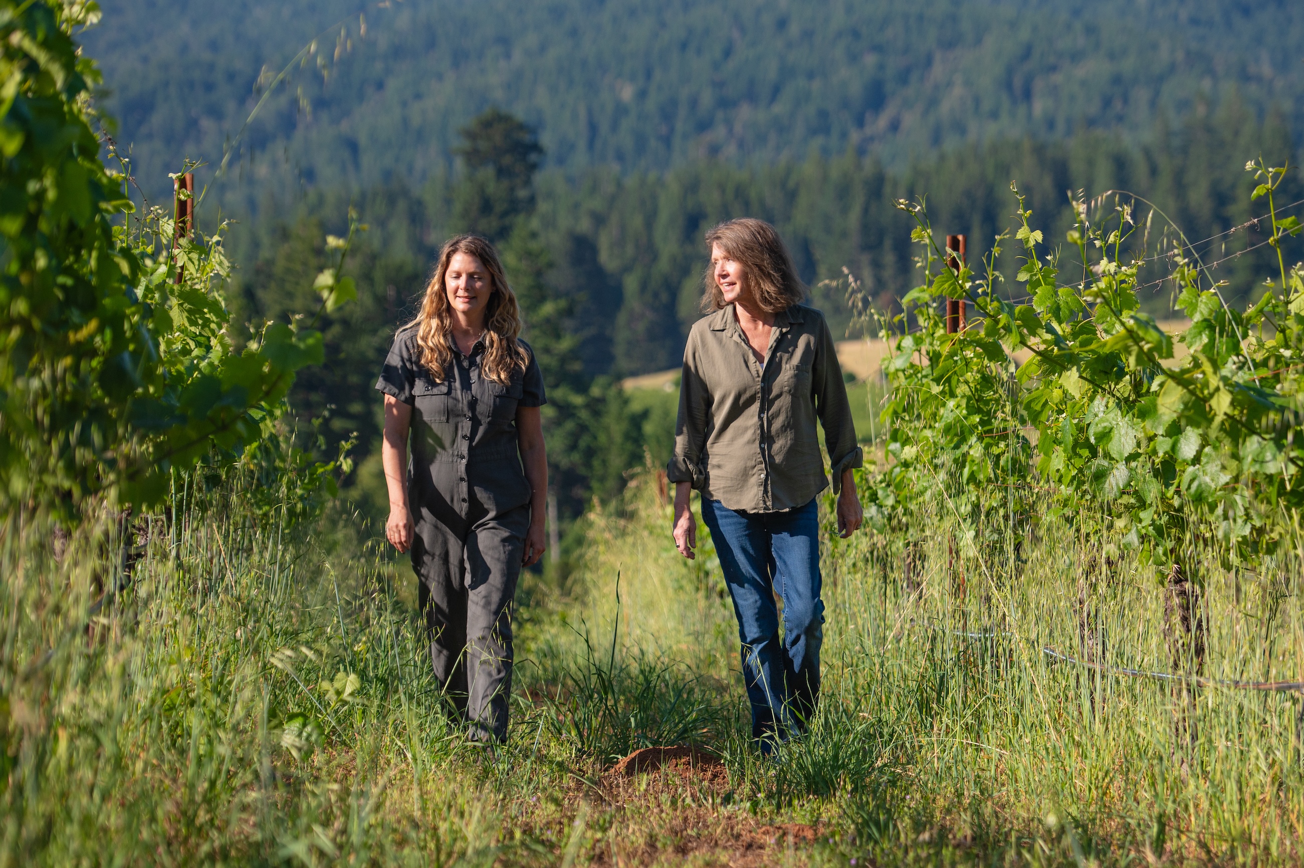 Brashley Vineyards winemaker Ashley Holland and co-owner Ashley Palm walk through an Anderson Valley vineyard with a tall cover crop.