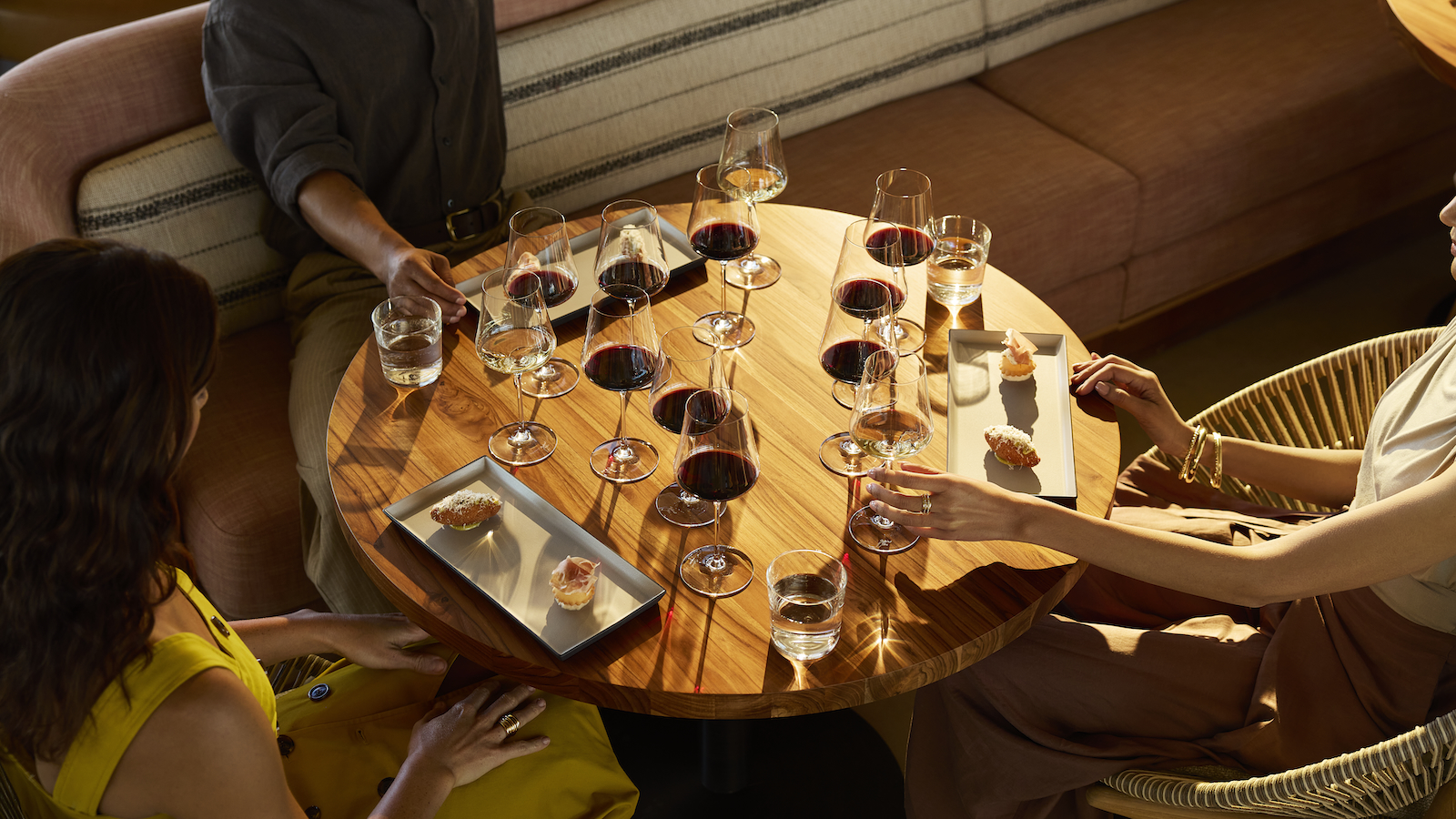 Three visitors enjoying the Legends Tasting, with several wine samples and bites of food, in Robert Mondavi's new Vineyard Room.